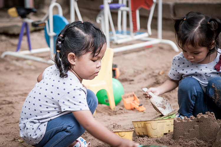 Child Playing with Sand in Playground Child Playing with Sand in Playground