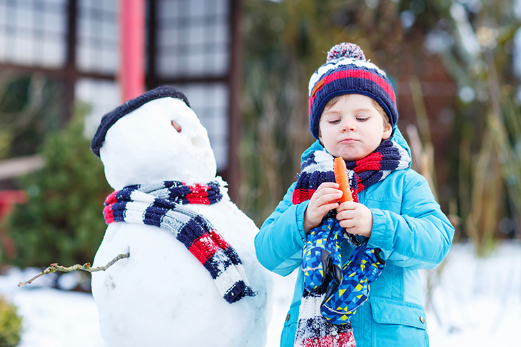 Funny Boy Making A Snowman In Winter Outdoors