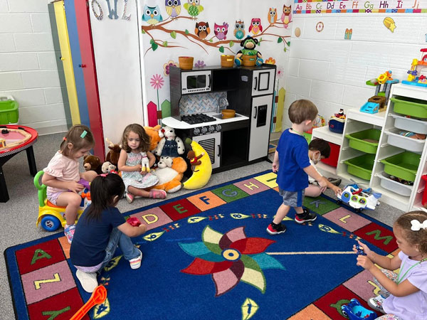 Classroom of children playing on a big carpet